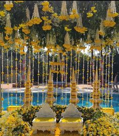 yellow flowers are hanging from the ceiling next to a pool