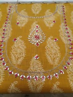 a yellow table cloth with red and white beads on it