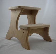 a wooden step stool sitting on top of a white sheet