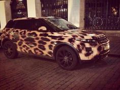 a leopard print suv is parked on the street