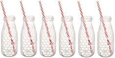 six clear glass bottles with red and white striped straws in them, all lined up