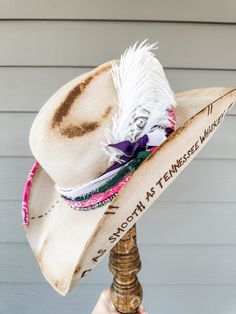 Silverbelly Hand Decorated Wool Cowgirl Hat Additional Information: Will need Head Measurement for hat All feathers and ribbons are glued to hold on to the hat. All hats are decorated, burned, hand-burned/engraved by Annrita Velardi Hat was burned, will have a slight odor at first. Please message us if you would like your hat personalized or have any questions. Branded Cowboy Hats, Feathered Hat Bands With Curved Brim For The Beach, Artisan Hat Bands For Kentucky Derby Festival, Feathered Hat Bands For Beach With Curved Brim, Curved Brim Hat Bands With Feathers For Western-themed Events, Brimmed Hat Bands With Feather Trim For Western-themed Events, Brimmed Hats With Feather Trim For Country Events, Fedora With Feather Trim For Rodeo, Western Costume Hat With Feathers