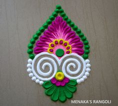 this is an image of a hand made rangolite decoration on a wooden surface