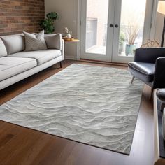 a living room filled with furniture and a rug on top of a hard wood floor