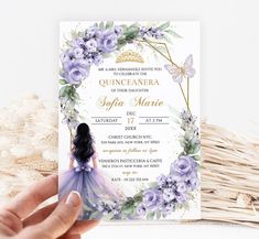 a hand holding up a purple and white wedding card with the word quince de mera on it