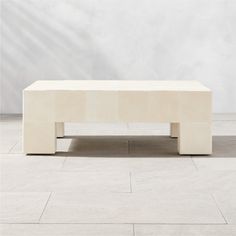 a white coffee table sitting on top of a tile floor