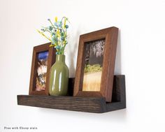 two wooden frames with flowers in them on a shelf next to a vase filled with flowers