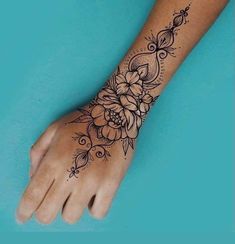 a woman's hand with a flower tattoo on the arm and wrist, which is decorated