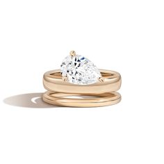 a pear shaped diamond engagement ring and wedding band set in 18k yellow gold,