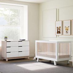 a baby's room with white furniture and pictures on the wall