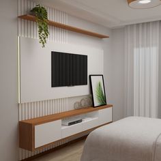 a bedroom with a bed, television and plant on the shelf in front of it