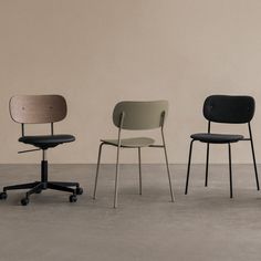 three chairs in different colors and sizes sitting on top of a cement floor next to each other