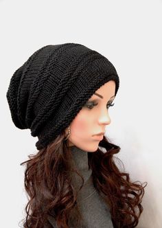 a mannequin head wearing a black knitted hat with long wavy brown hair