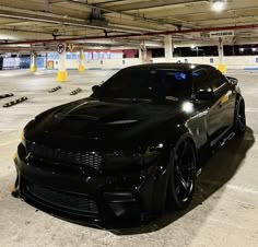 a black sports car is parked in a parking garage with lights on it's headlamps