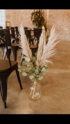 a vase filled with flowers sitting on top of a table next to a black chair