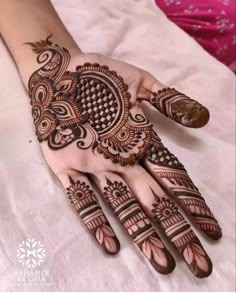 a henna is shown on the palm of a woman's hand, with intricate designs