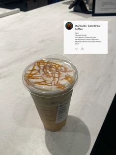 a cup of coffee sitting on top of a counter next to a sign that reads starbucks cold brew