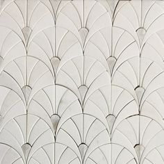 an art deco tile pattern in white and grey tones with fan shaped design on the back