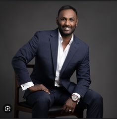 a man in a suit sitting on a chair