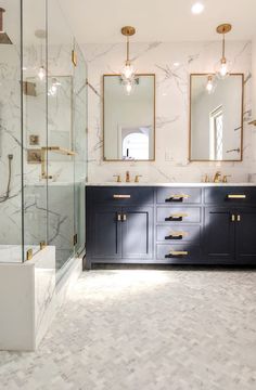 a bathroom with marble counter tops and gold trimming on the mirrors above the sinks