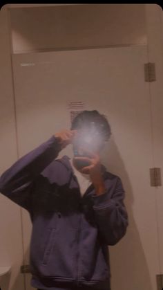 a person taking a selfie in front of a mirror with a light shining on them