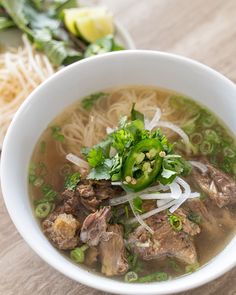 a white bowl filled with meat and noodles