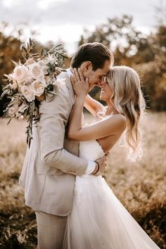 a bride and groom kissing in a field