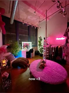 a room with pink carpet and clothes hanging on the wall, lights in the window