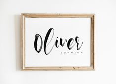 a framed print with the word alive in cursive black ink on white paper