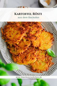 potato fritters on a plate with basil leaves in the background and text that reads kartoffel rosti aus dem backen