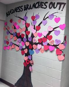 a bulletin board with hearts on it and a tree made out of paper in the middle