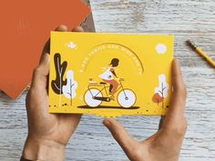 a person holding up a yellow card with an image of a woman on a bike