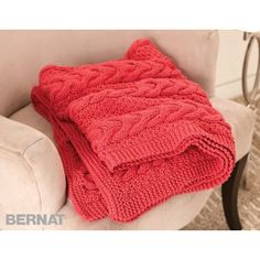 a red blanket sitting on top of a white chair