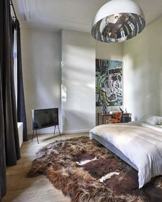 a bedroom with a large bed and an animal skin rug on the floor in front of it