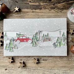 a christmas card with a red car driving through the snow and trees in front of it