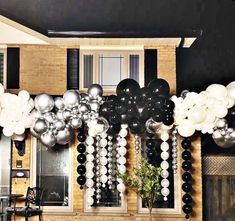 black and white balloons are hanging from the ceiling