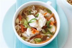 there is noodle soup with carrots and dumplings in the bowl