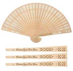 three wooden fans with laser cutouts on the front and back, one in white