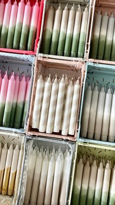 many different colored candles in boxes on display