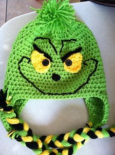 a crocheted green hat with yellow and black braids