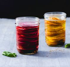 two jars filled with food sitting on top of a table