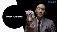 a man in a suit and tie holding up a mask with the words park hae - soo on it