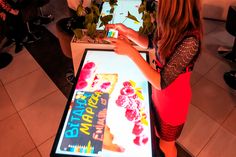 a woman standing in front of a table with a video game on top of it