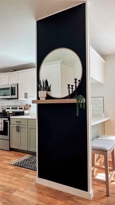 a black and white kitchen with a round mirror on the wall