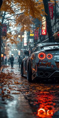 a car parked in the rain on a city street with people walking down the sidewalk