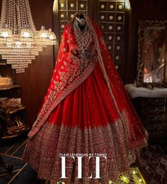 a red lehenga on display in front of a chandelier