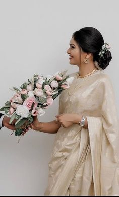 two people standing next to each other holding flowers