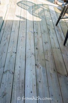 a wooden deck with chairs on it and people sitting in the back ground looking at something