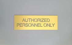 a yellow sign that says authorized personnel only on the side of a gray wall in an office