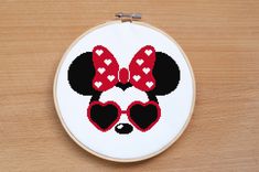 a cross - stitch mickey mouse with heart shaped sunglasses on it's face is shown